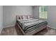Neutral bedroom featuring a queen bed with a patterned duvet and natural light from a window at 703 Pointe Andrews Dr, Concord, NC 28025
