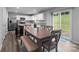 Bright dining area with wood table, bench seating, and sliding glass doors to the backyard at 703 Pointe Andrews Dr, Concord, NC 28025