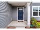 Charming entrance featuring a classic blue door, decorative columns, and lush landscaping details at 703 Pointe Andrews Dr, Concord, NC 28025