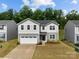 Inviting two-story home featuring a well-maintained lawn, a two-car garage, and classic architectural details at 703 Pointe Andrews Dr, Concord, NC 28025