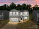 Charming two-story home showcasing manicured landscaping and an inviting facade under a vibrant twilight sky at 703 Pointe Andrews Dr, Concord, NC 28025