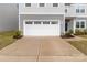 Spacious two car garage with a large concrete driveway and manicured flowerbeds at 703 Pointe Andrews Dr, Concord, NC 28025