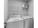 Clean laundry room with a washer, dryer, and wire shelving for storage at 703 Pointe Andrews Dr, Concord, NC 28025