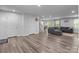 Open-concept living room boasts stylish laminate floors, modern lighting, and seamless access to staircase at 703 Pointe Andrews Dr, Concord, NC 28025