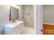 Bathroom showcasing marble tile shower, mosaic floor, and a vanity with a gold faucet at 7101 City View Dr, Charlotte, NC 28212