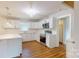 Modern kitchen boasts white cabinets, stainless steel appliances, and an eat-in island with quartz countertops at 7101 City View Dr, Charlotte, NC 28212