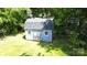 Light blue shed with double doors and 2 windows amid trees at 7101 City View Dr, Charlotte, NC 28212