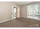 Spacious carpeted bedroom with a large window, neutral walls, and access to outdoor patio at 718 W Trade St, Charlotte, NC 28202