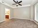 Large bedroom featuring neutral walls, ceiling fan, plush carpet, and connecting bathroom at 718 W Trade St, Charlotte, NC 28202