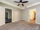 Spacious bedroom with ceiling fan, tiled entryway, neutral walls, and carpeted floors at 718 W Trade St, Charlotte, NC 28202
