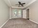 Bright bedroom with a ceiling fan, plush carpet, and well-lit from two large windows at 718 W Trade St, Charlotte, NC 28202