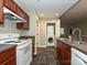 Functional kitchen with stainless steel appliances, brown cabinets, and open laundry area at 718 W Trade St, Charlotte, NC 28202