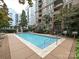 Exterior shot of the pool, complete with lounge chairs, umbrellas and mature landscaping at 718 W Trade St, Charlotte, NC 28202