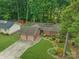 Aerial view of home with a two-car garage, long driveway, lush lawn, and mature trees at 7312 Barcliff Dr, Charlotte, NC 28212