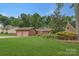Well-maintained single-story home featuring a two-car garage, manicured lawn, and mature landscaping at 7312 Barcliff Dr, Charlotte, NC 28212