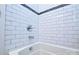 White tiled shower with modern fixtures and a black tile accent at 8024 Eagle St, Mount Pleasant, NC 28124