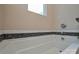 Soaking tub with decorative tile surround and chrome fixtures at 8024 Eagle St, Mount Pleasant, NC 28124