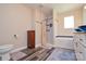 Bright bathroom features a tub/shower combo, wood-look flooring, and stylish vanity at 8024 Eagle St, Mount Pleasant, NC 28124