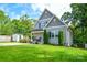 Charming gray home with mature trees, inviting front porch, and a spacious green lawn at 8024 Eagle St, Mount Pleasant, NC 28124