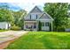 Charming two-story home with gray siding, black shutters, a lush green lawn, and mature trees at 8024 Eagle St, Mount Pleasant, NC 28124