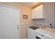 This laundry room has white cabinets and features a patterned accent wall at 8024 Eagle St, Mount Pleasant, NC 28124