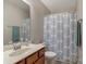 A clean bathroom with a wood vanity and shower-tub combo with a blue pattern curtain at 8031 Scarlet Oak Ter, Indian Land, SC 29707