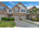 Attractive townhome showcasing a well-maintained lawn, individual garages, and a welcoming facade under a blue sky at 8031 Scarlet Oak Ter, Indian Land, SC 29707