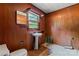 Bathroom with wood paneling, pedestal sink and a window providing natural light at 804 Gw Broome Rd, Monroe, NC 28112