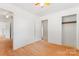 Bright bedroom featuring hardwood floors, ceiling fan, and convenient closet space at 804 Gw Broome Rd, Monroe, NC 28112