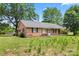 Charming brick home with a well-manicured lawn and mature trees offering ample shade at 804 Gw Broome Rd, Monroe, NC 28112