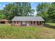 Quaint single-story brick house featuring classic shutters and a covered porch in a serene setting at 804 Gw Broome Rd, Monroe, NC 28112