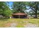 Outbuilding with a shed roof surrounded by lush trees and foliage at 804 Gw Broome Rd, Monroe, NC 28112