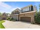Exterior elevation showing a brick facade and large garage with expansive driveway at 8701 Highgrove St, Charlotte, NC 28277