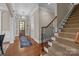Foyer with hardwood floors, staircase, and a decorative light fixture creates a welcoming entrance at 8701 Highgrove St, Charlotte, NC 28277