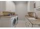 Laundry room with granite countertops, basin sink, cabinetry, and modern washer and dryer units at 8701 Highgrove St, Charlotte, NC 28277