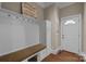 Mudroom with bench seating, storage hooks, cabinet, and hardwood flooring near the front door at 8701 Highgrove St, Charlotte, NC 28277