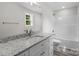 Bathroom with granite countertop vanity, tub and shower combo, and a window at 894 Oval St, Kannapolis, NC 28081