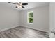 Bedroom featuring a ceiling fan, window, and gray wood-look flooring at 894 Oval St, Kannapolis, NC 28081
