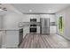 Bright kitchen with stainless steel appliances, granite countertops, white cabinets, and gray vinyl plank flooring at 894 Oval St, Kannapolis, NC 28081