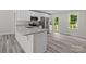Modern kitchen with white cabinets, stainless steel appliances, granite countertops, and gray vinyl plank flooring at 894 Oval St, Kannapolis, NC 28081