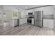 Well-appointed kitchen with white cabinetry, stainless steel appliances, and granite countertops overlooking the living area at 894 Oval St, Kannapolis, NC 28081