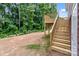New wooden staircase leading to a home's backyard featuring a natural wooded backdrop at 896 Oval St, Kannapolis, NC 28081