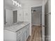 Bathroom vanity with white cabinets, granite countertop, modern mirror, and wood-look floor at 896 Oval St, Kannapolis, NC 28081