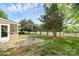 Landscaped backyard featuring a stone patio, lush green lawn, mature trees, and partial fence line at 9157 Snow Hill Ct, Charlotte, NC 28269