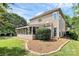 Home exterior featuring a screened-in porch, manicured lawn, lush shrubbery, and outdoor patio at 9157 Snow Hill Ct, Charlotte, NC 28269