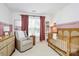 Charming Bedroom featuring a cozy chair, stylish crib, and pink accents at 9157 Snow Hill Ct, Charlotte, NC 28269