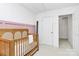 Bright Bedroom with a wooden crib and pastel pink accent wall, creating a serene and comforting space at 9157 Snow Hill Ct, Charlotte, NC 28269