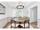 Bright dining room with wood table, modern chandelier, and wainscoting, creating an inviting atmosphere at 9157 Snow Hill Ct, Charlotte, NC 28269