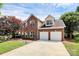 Brick home with a manicured lawn, mature trees, two-car garage, and a large driveway at 9157 Snow Hill Ct, Charlotte, NC 28269