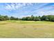 Expansive view of a golf course with manicured greens, sand traps, and rolling hills on a clear day at 9157 Snow Hill Ct, Charlotte, NC 28269
